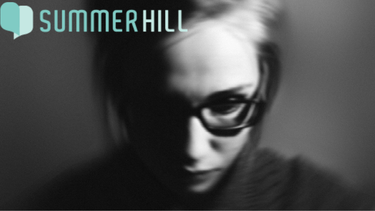 Black and white photo of a woman appearing stressed, disturbed, and depressed, with a tense expression and downcast eyes.