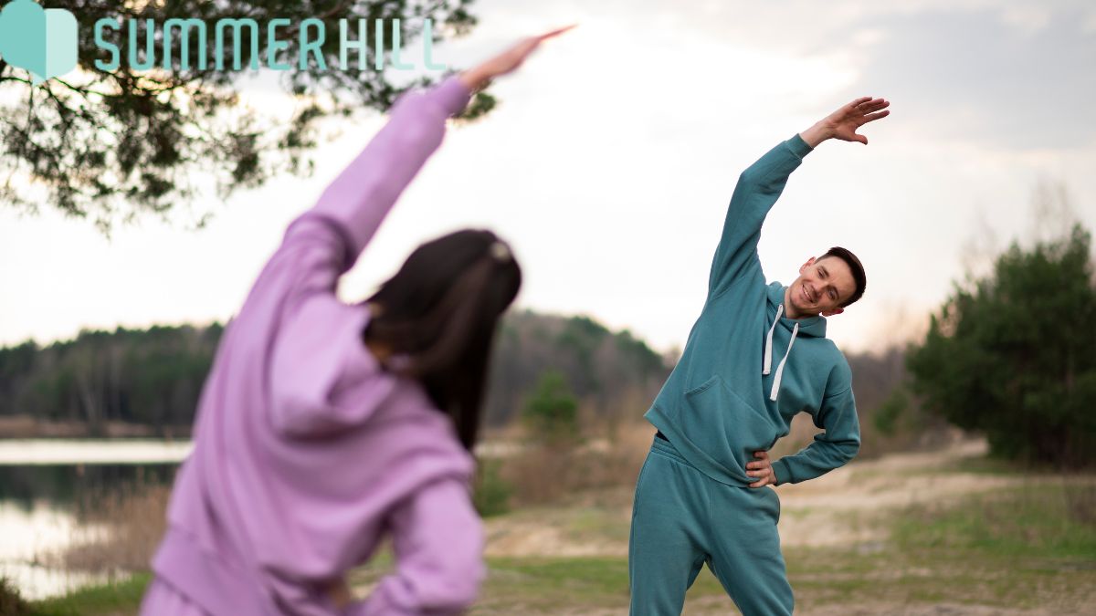Physical and mental health, a man and woman stretch together during an outdoor workout.