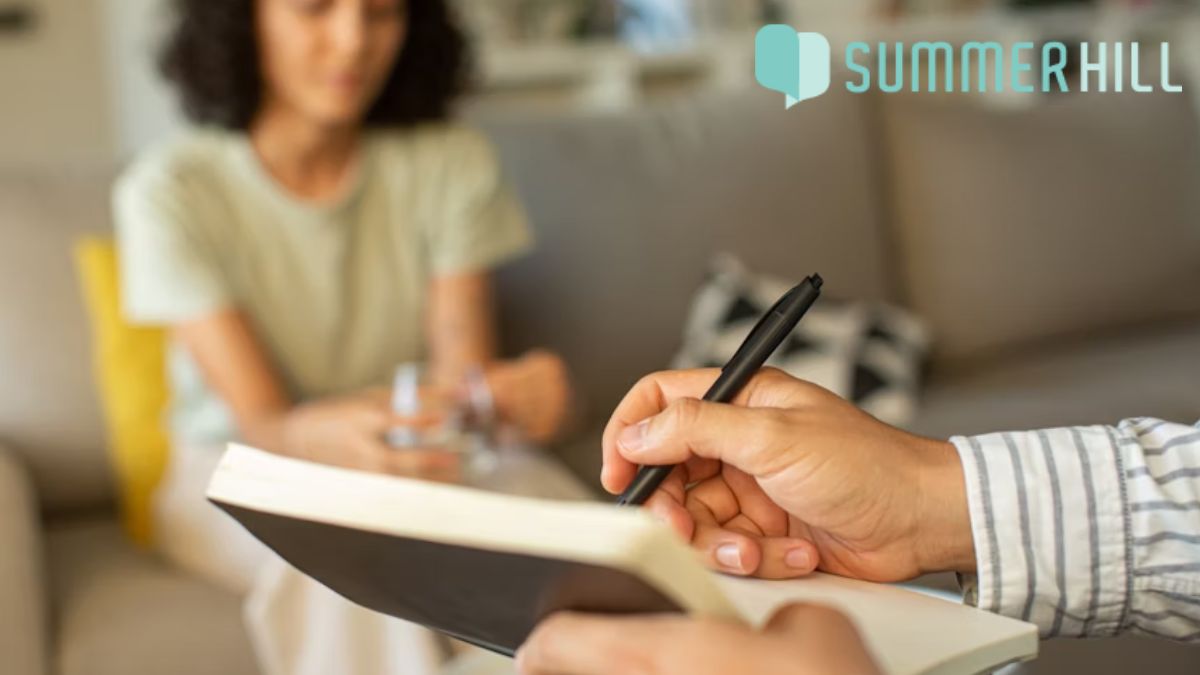 A young woman sits calmly in soft focus, engaging in talk therapy during a CBT session for bipolar disorder.
