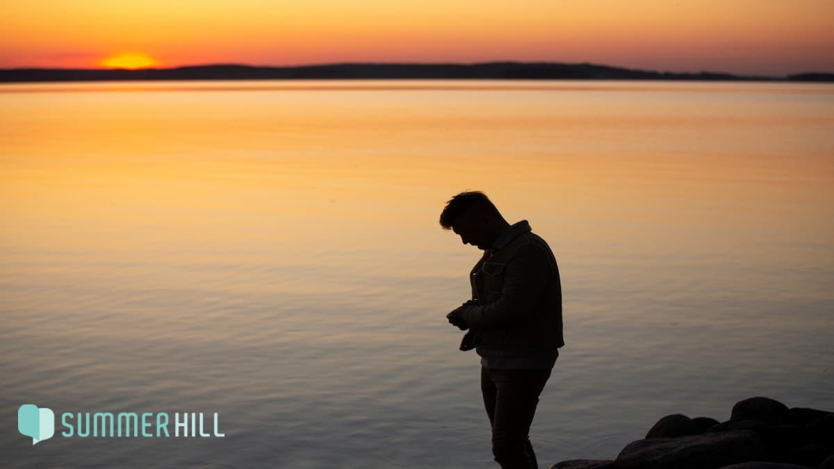 Sad and contemplative person near lake