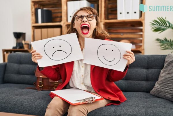A women holding emojis of two moods