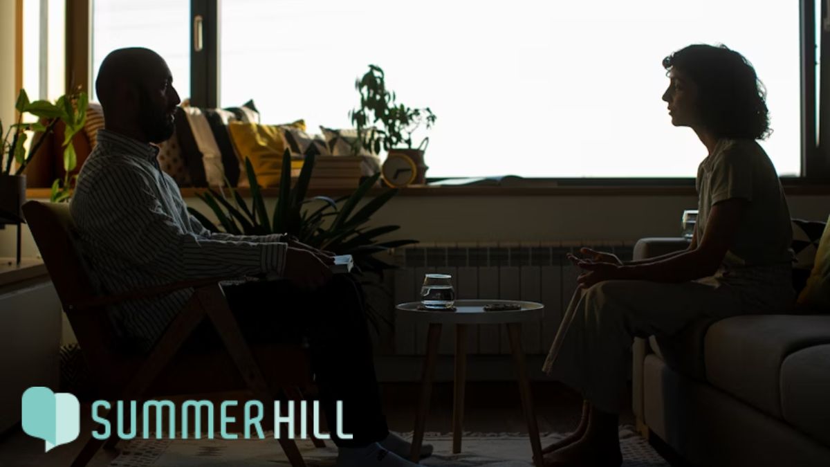 Outgrown your current therapist: a female patient and her therapist sit at eye level, facing each other in a dimly lit room. 