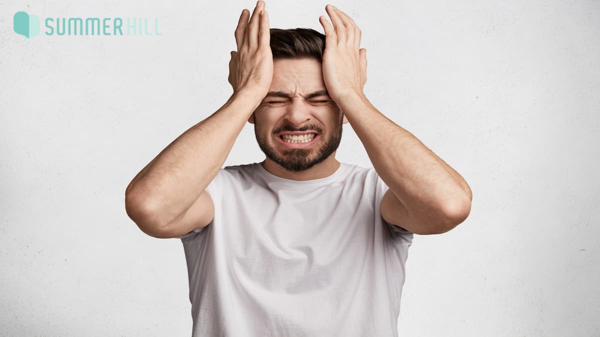 Man holding his forehead with both hands in stress
