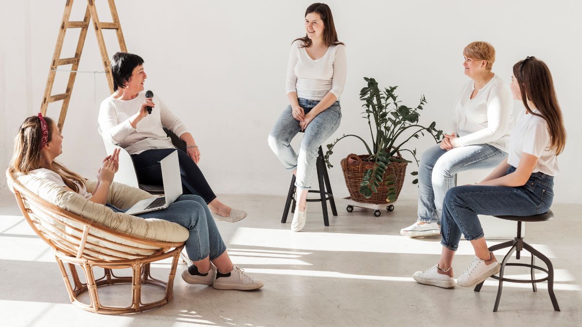 Women engage in a calming indoor therapy session focused on self-care practices.